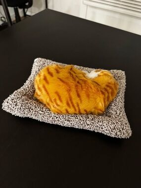 Plush Orange Tabby Cat on Gray Bed